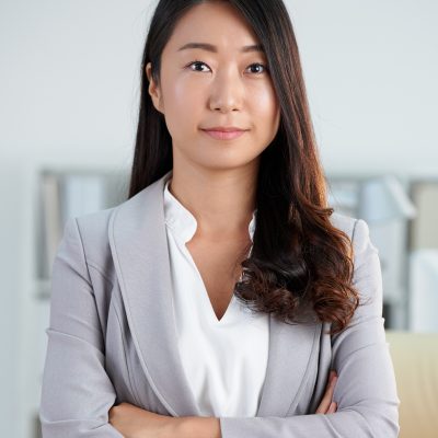 Portrait of confident young woman standing with her arms crossed